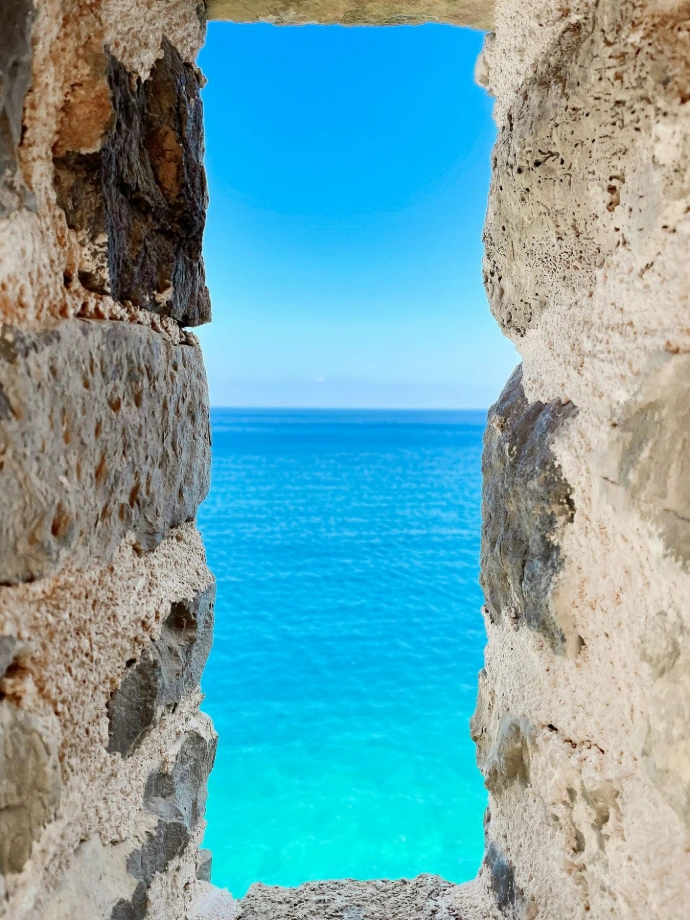 a view of the ocean through a stone window